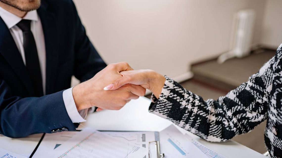 Imagen de empresario y asesor de pymes formalizando un acuerdo para el que se dan la mano para su conformidad