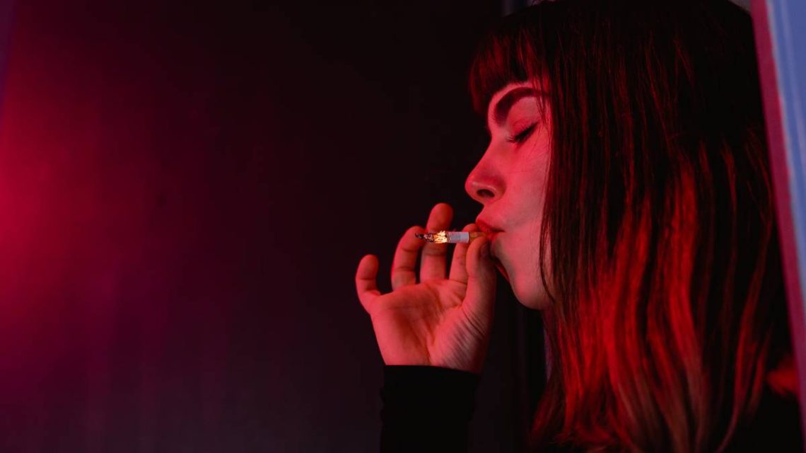 Imagen de una chica joven dependiente de fumar drogas