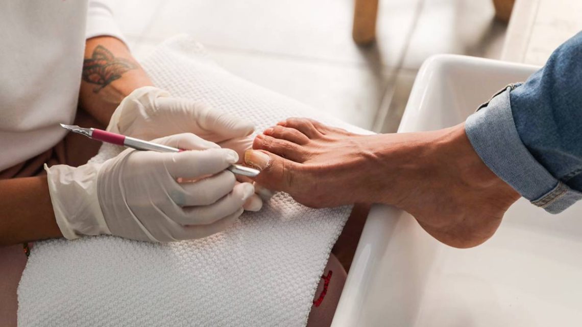 Imagen de profesional de cuidado de los pies con un cliente en el momento de trabajo