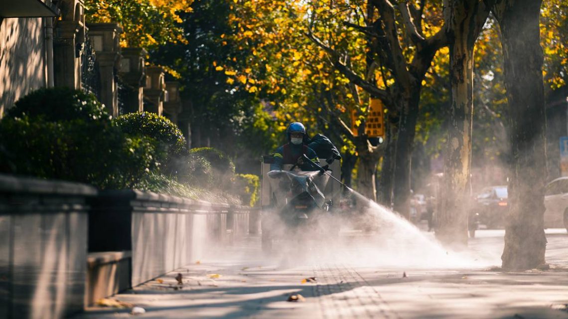 Imagen de un trabajador de una empresa de fumigaciones en Madrid realizando su trabajo en motocicleta en un dia de otoño en la capital de España