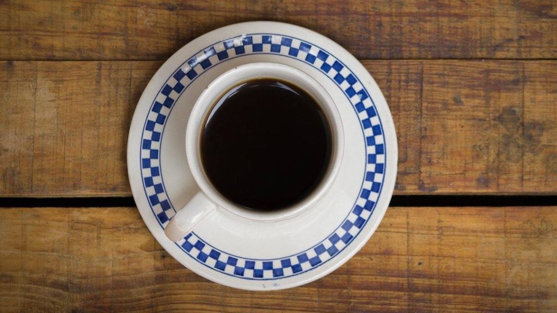 Imagen de una taza de cafe solo tomada desde una perspectiva en la que se ve todo el conido y su color negro molido